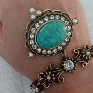 Gold tone turquoise medallion bracelet with gem's and pearl like accents.